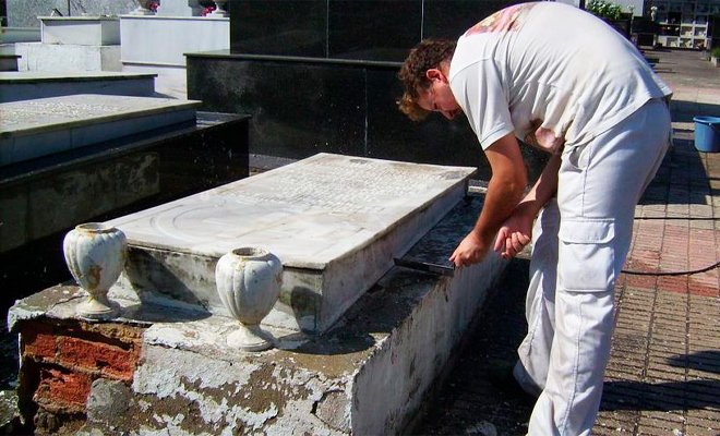 Operario reparando nicho de cementerio